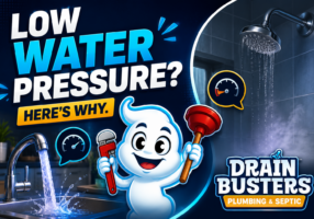 A bold, high-contrast promotional image designed for a plumbing blog about low water pressure problems. The graphic uses DrainBusters Plumbing & Septic’s signature navy blue, cyan, yellow, white, and red branding colors.

On the left side, large white and bright blue lettering says:
“LOW WATER PRESSURE?”
with a yellow banner underneath reading:
“HERE’S WHY.”

The center of the image features the DrainBusters mascot — a cheerful white character holding a red pipe wrench and plunger. Behind the mascot are speech-bubble style pressure gauge icons representing plumbing pressure issues.

The background includes a modern kitchen sink faucet with flowing water and a bathroom showerhead with visibly weak water flow to visually represent fluctuating water pressure throughout a home.

The DrainBusters Plumbing & Septic logo appears prominently in the lower-right corner, reinforcing the company branding and creating a clean, professional blog header image optimized for SEO and social sharing.